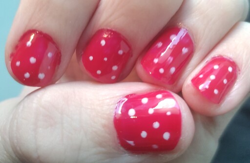 Nails of my left hand painted red with white dots